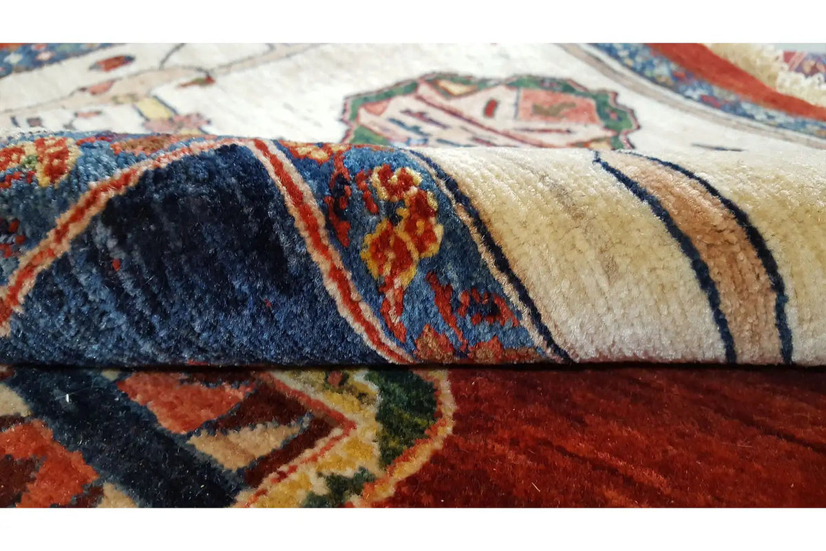 Close-up of a carpet: woven patterns in red, blue, and beige with colorful borders