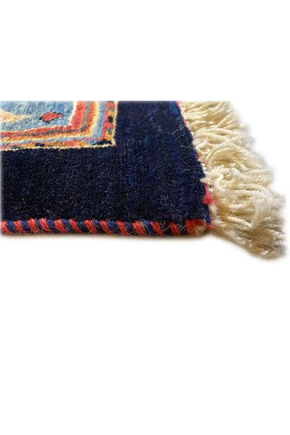 Rug with a dark blue surface and white fringes along the edge
