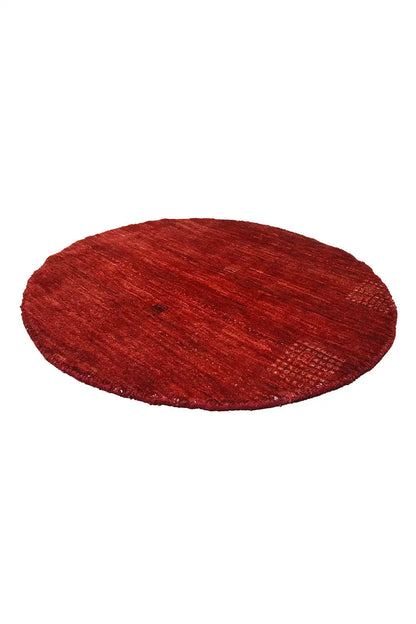 Gabbeh textile in red, appearing oval, with a fine fiber structure
