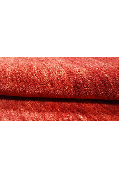 Red Gabbeh rug with a visible edge and high pile height