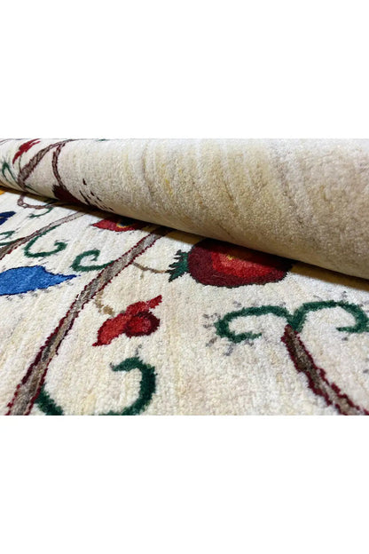 Close-up: woven rug with beige pile and colorful embroidered patterns