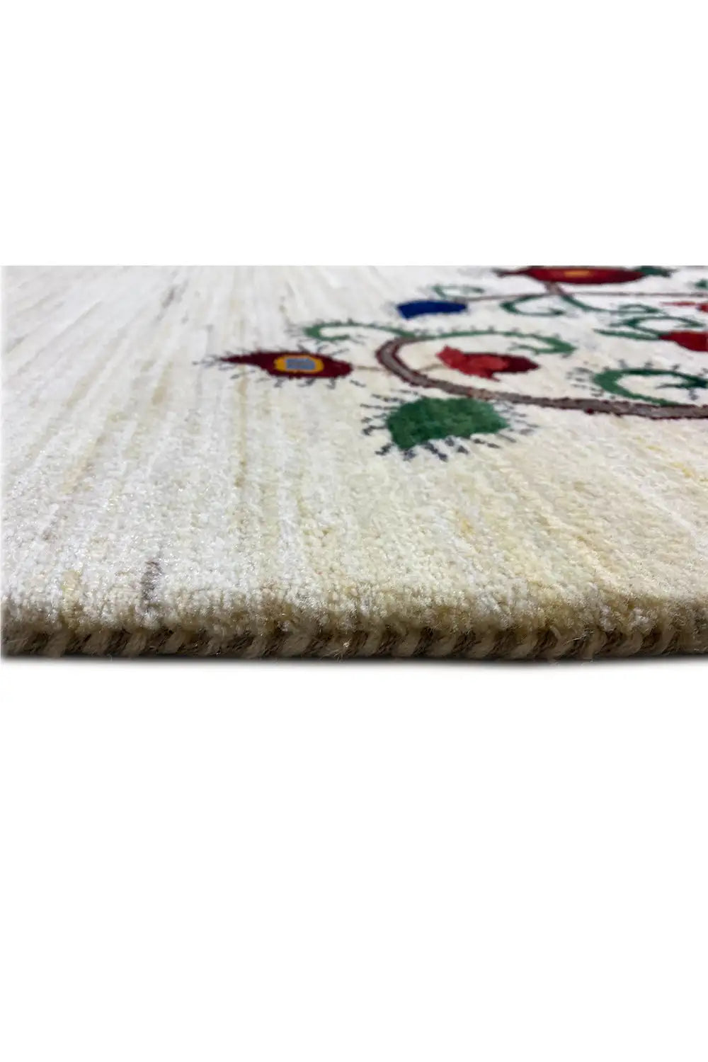 Close-up of the rug edge with beige pile and a colorful pattern