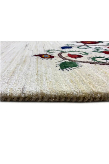 Close-up of the rug edge with beige pile and a colorful pattern