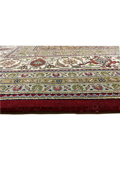 Indo Tabriz carpet detail at the edge: decorative border with fringes, multicolored on a light background