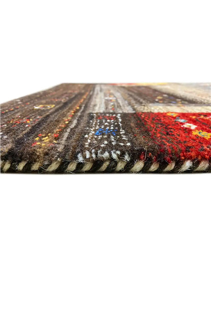 Carpet edge in close-up: frayed pile and a warm red-yellow panel, with gray underneath