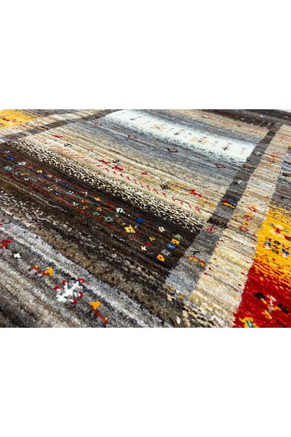 Carpet pile in detail: multicolored embroidered patterns on gray/brown with a red accent