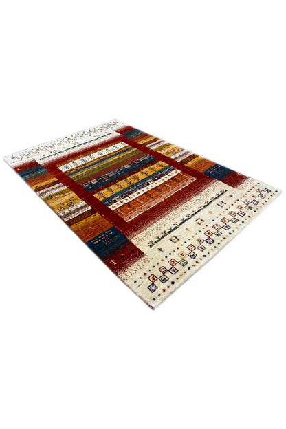 Gabbeh rug (140x97 cm) at an angle: red central structure, blue accents, yellow stripes