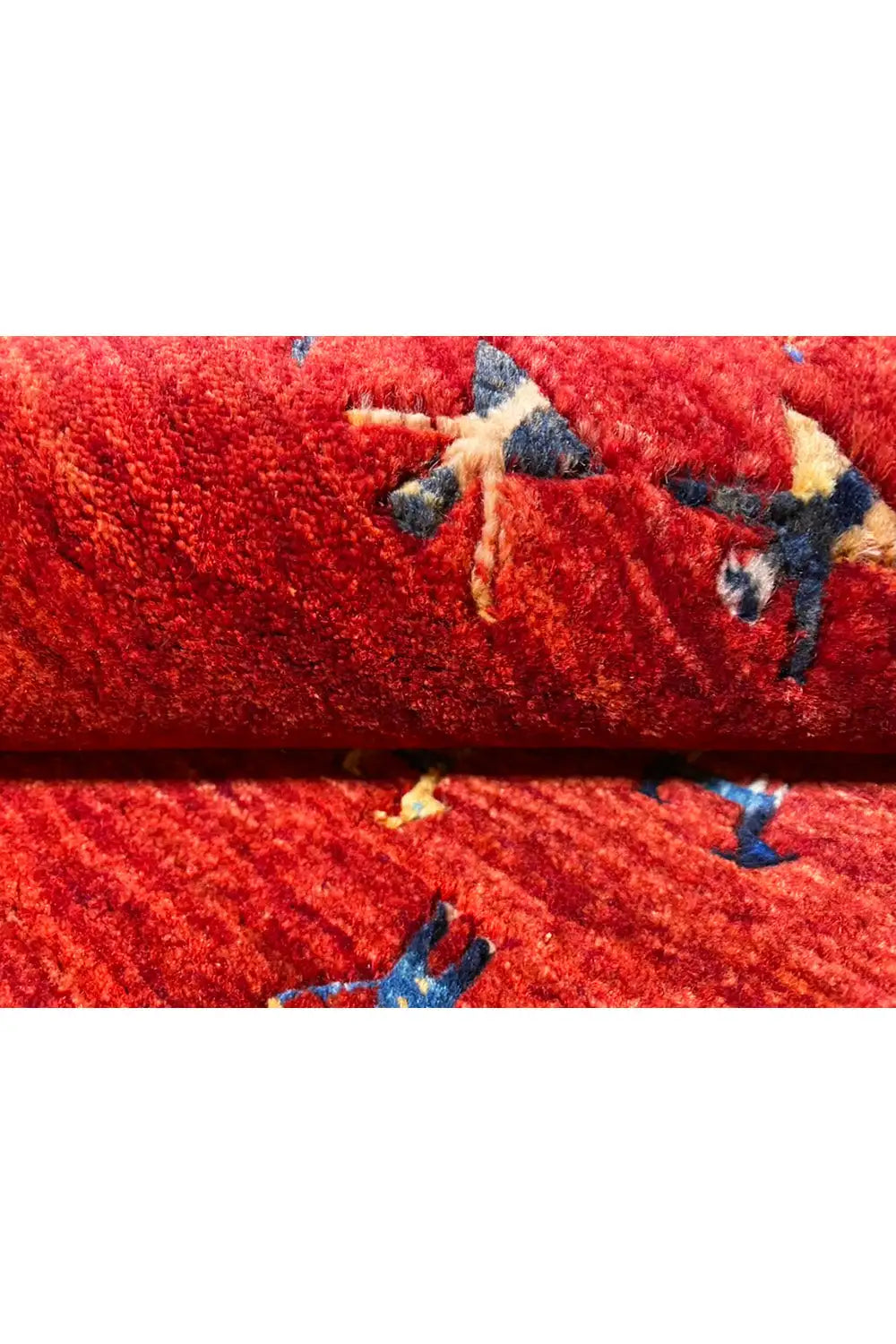 Gabbeh rug: reddish-brown pile with a blue accent, detail of the patterns and texture