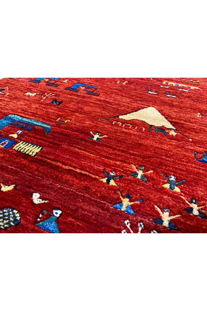 Gabbeh rug close-up: red weave with colorful figures and ornaments