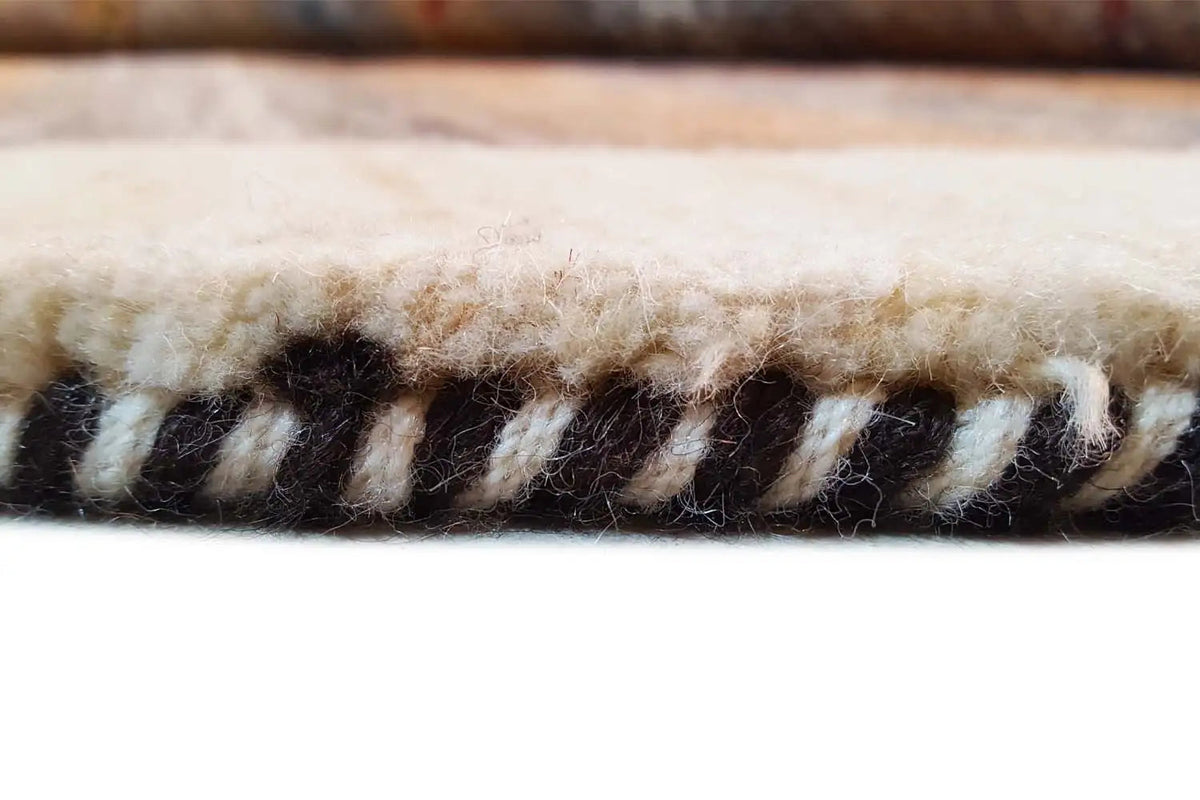 Gabbeh rug: framed border with tassels and black-and-beige yarns