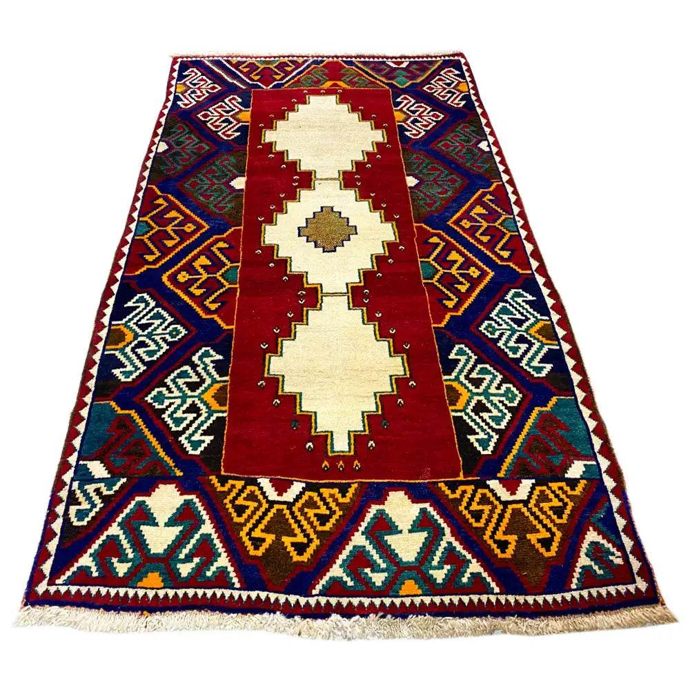 Gabbeh rug: three cream medallions on a red field, blue zigzag border, fringes