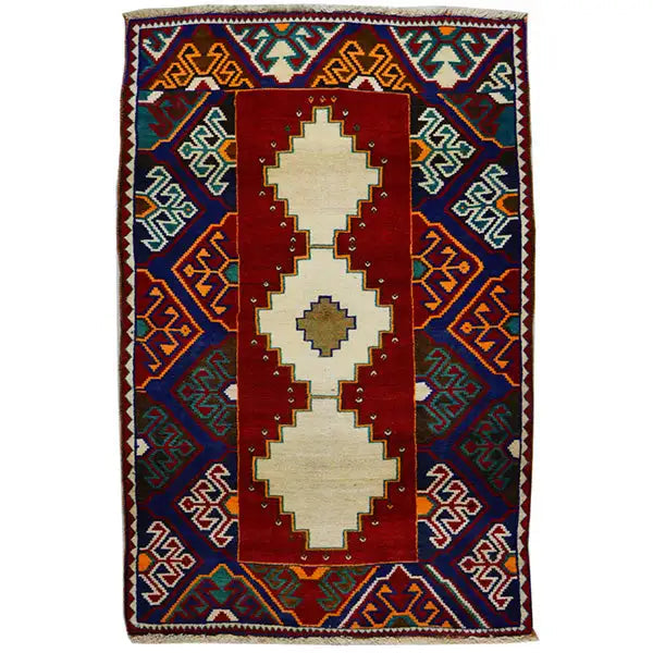 Gabbeh rug: red medallion with cream patterns, blue border ornament, fringes