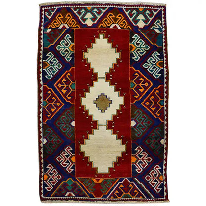 Gabbeh rug: red medallion with cream patterns, blue border ornament, fringes