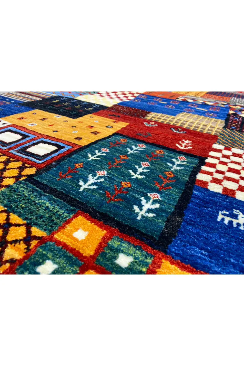 Gabbeh rug close-up: geometric squares and floral ornaments in blue-green and red