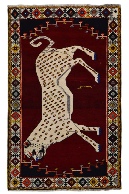 Gabbeh rug with a beige animal motif and deep red background, framed by a colorful border