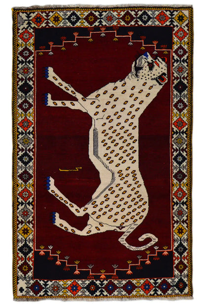 Gabbeh rug with a large animal motif in beige on dark red, surrounded by an ornamental border