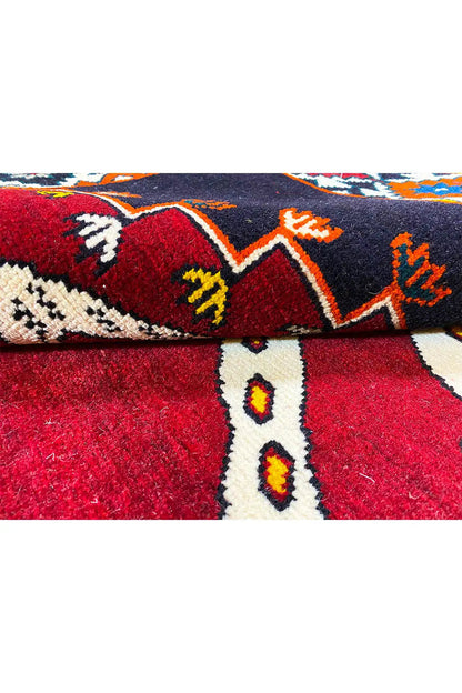 Gabbeh rug view with pattern and pile texture, dark and red areas with colorful motifs