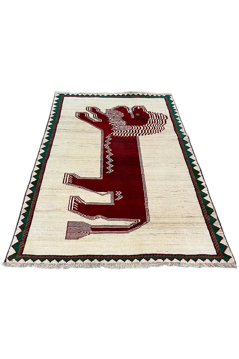 Gabbeh rug with a beige background, red hook pattern, and green decorative border