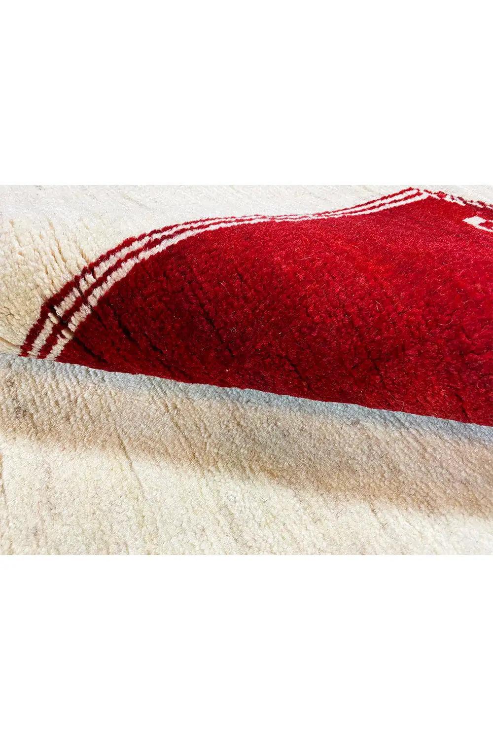 Gabbeh rug with a red field motif, a white-beige border, and side fringe seam