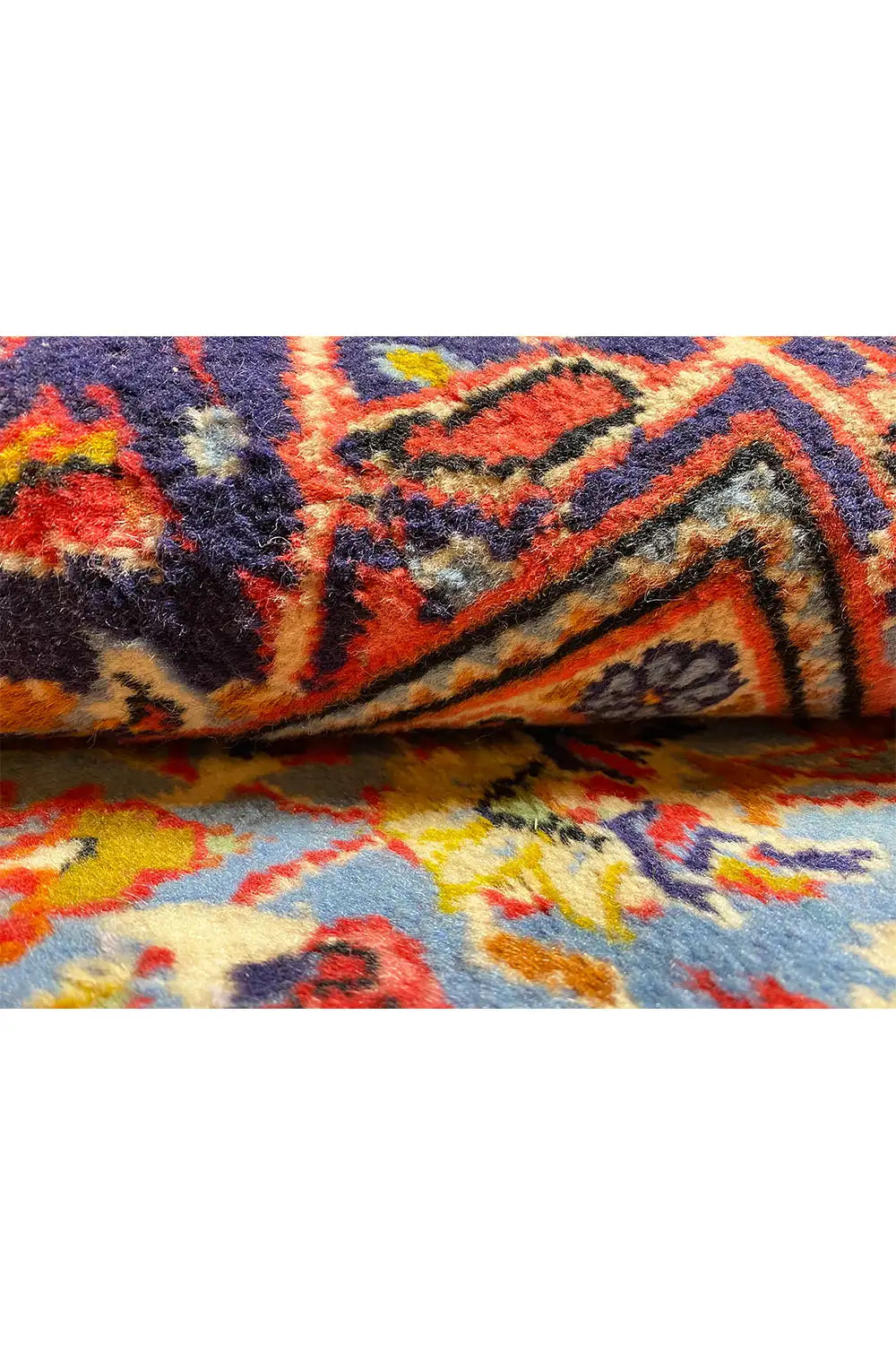 Carpet detail: colorful ornament and woven texture on a dark blue background