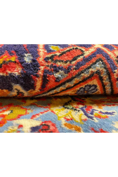 Carpet detail: colorful ornament and woven texture on a dark blue background