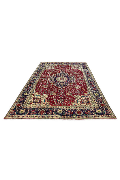 Tabriz carpet lying flat, red field with patterned borders in blue and yellow