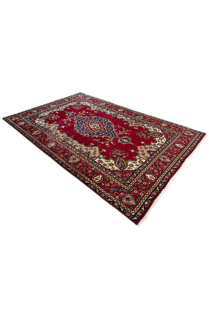 Red Oriental rug with a large medallion in the center and a detailed border pattern