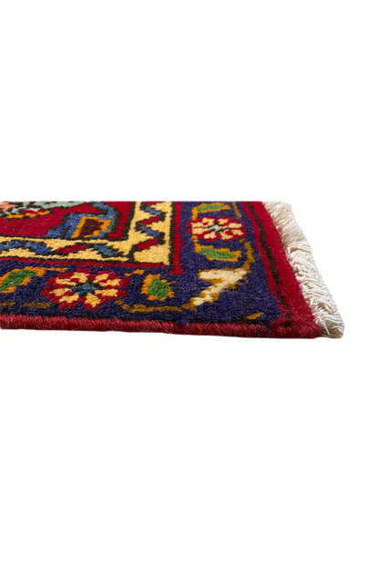 Rug edge with multicolored pattern and fringed finish, red