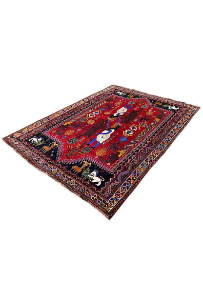Oriental rug with a red field and central figurative pattern, spread diagonally