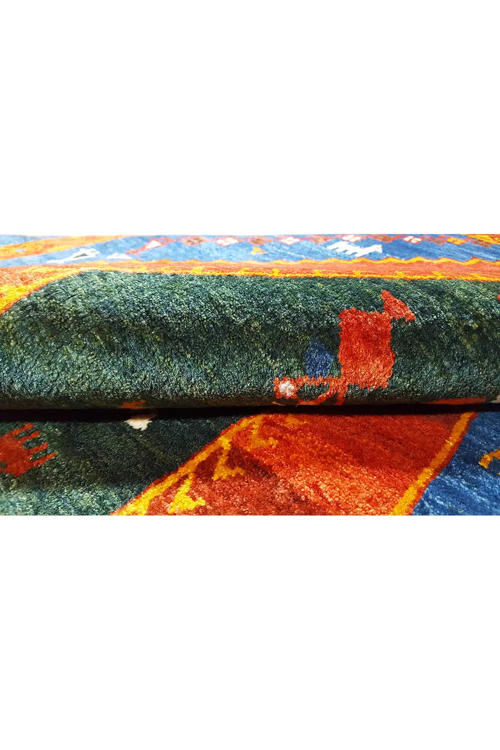 Gabbeh rug side view: green pile surface with colorful border strips