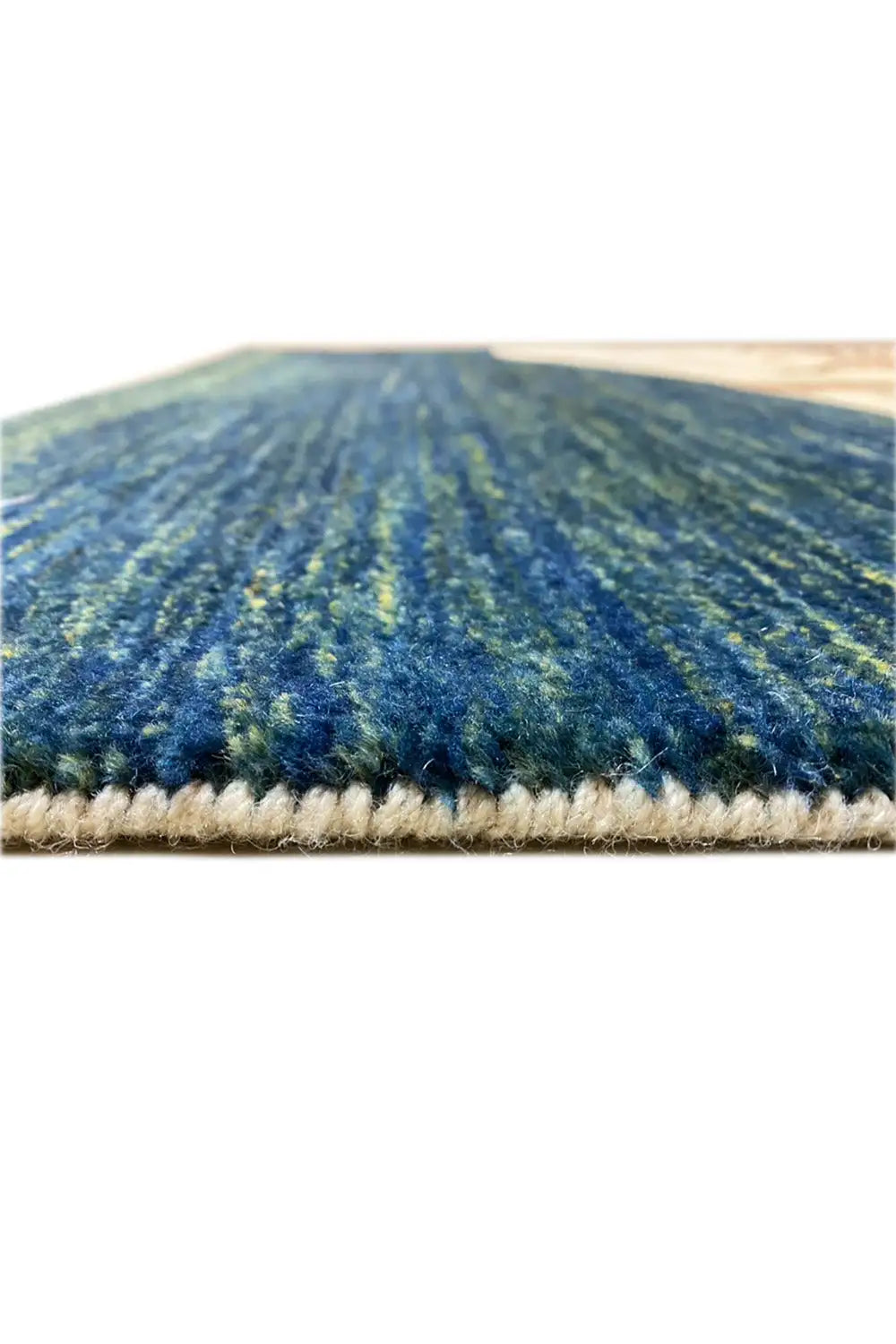 Close-up of the Gabbeh rug: dark blue texture with a fine pile and beige overcast edge.