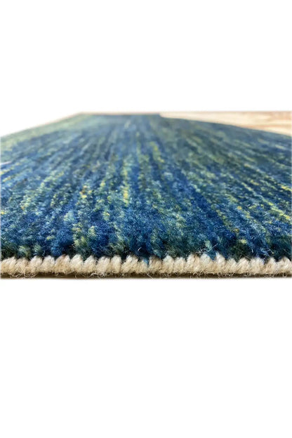Close-up of the Gabbeh rug: dark blue texture with a fine pile and beige overcast edge.