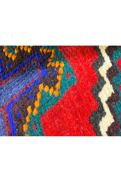 Close-up of carpet pile: colorful patterns made from blue, red, turquoise, and beige yarn
