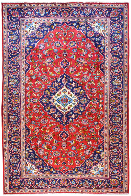 Keshan rug with a red medallion, blue border, and multicolored ornaments, rectangular