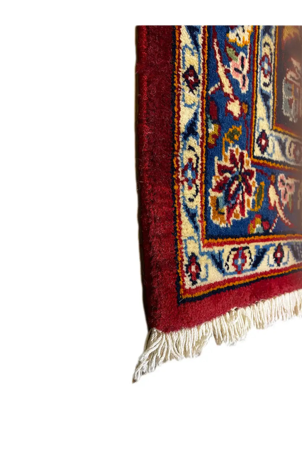 Oriental rug corner with red and blue ornaments and long fringes