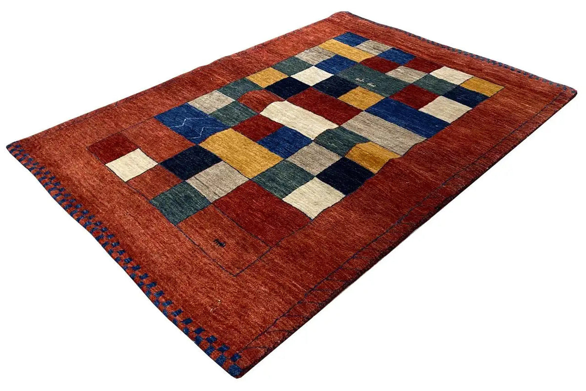 Lori gabbeh rug with a geometric patchwork pattern in red, blue, beige, and green