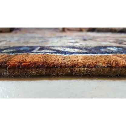 Designer rug: brown wool pile with a neatly finished rug edge in detail
