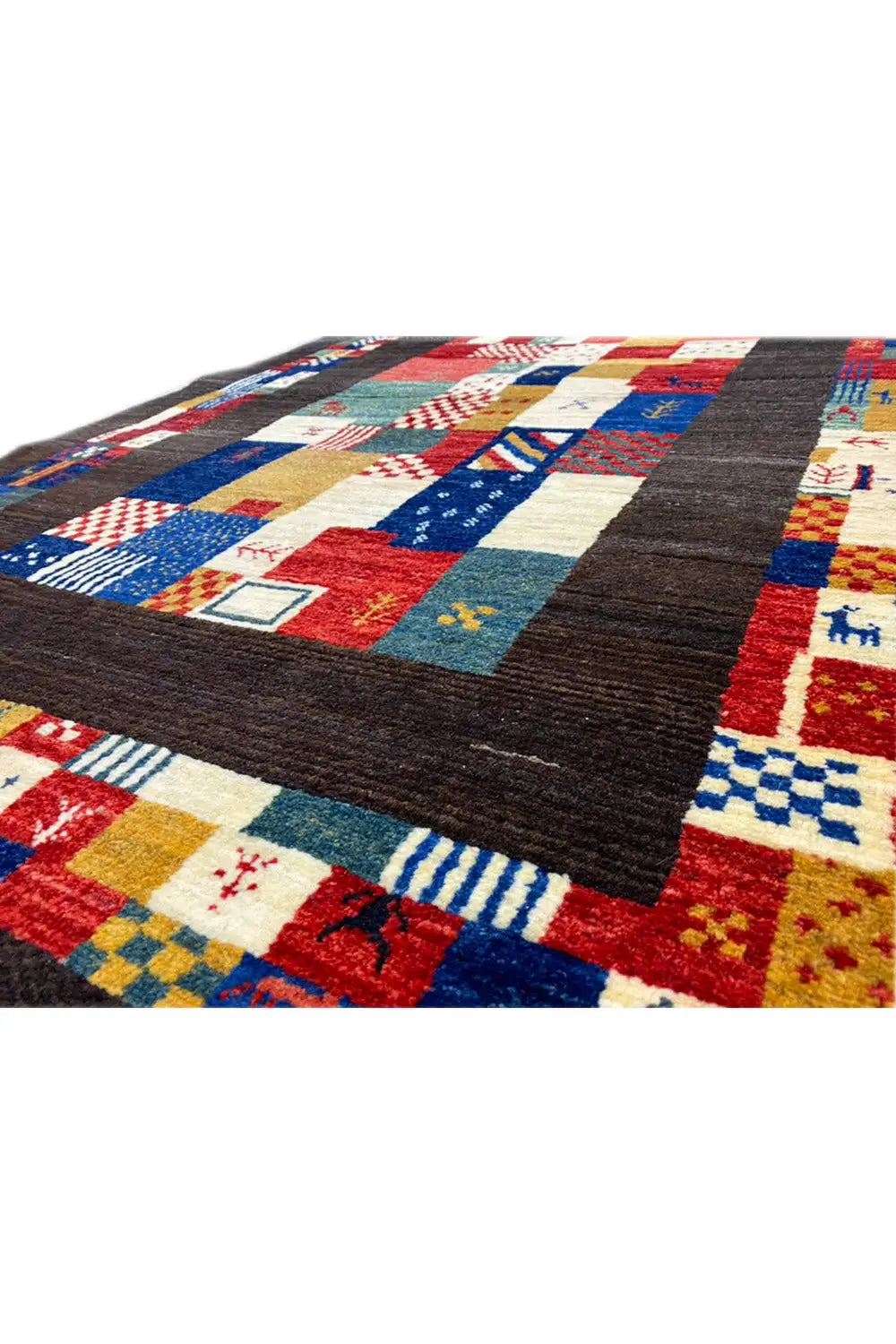 Gabbeh rug 169x107 cm, corner detail: patchwork in red, blue, and beige on dark brown