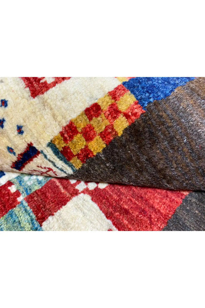 Gabbeh rug 169x107 cm, close-up of the woven edge and patchwork motifs in red, blue, and beige