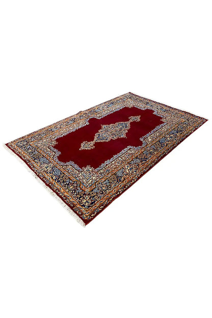 Red Kerman carpet with a blue and gold medallion and border ornaments
