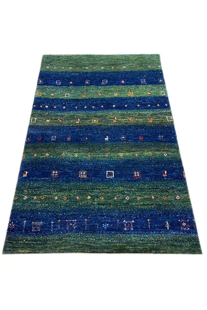 Gabbeh rug 128x81 cm, photographed in a trapezoidal shape, green-blue with colorful motifs