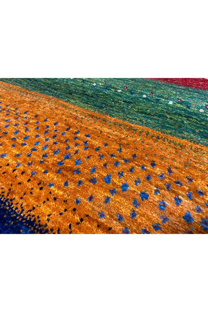 Close-up of a Gabbeh rug, orange section with blue and green threads