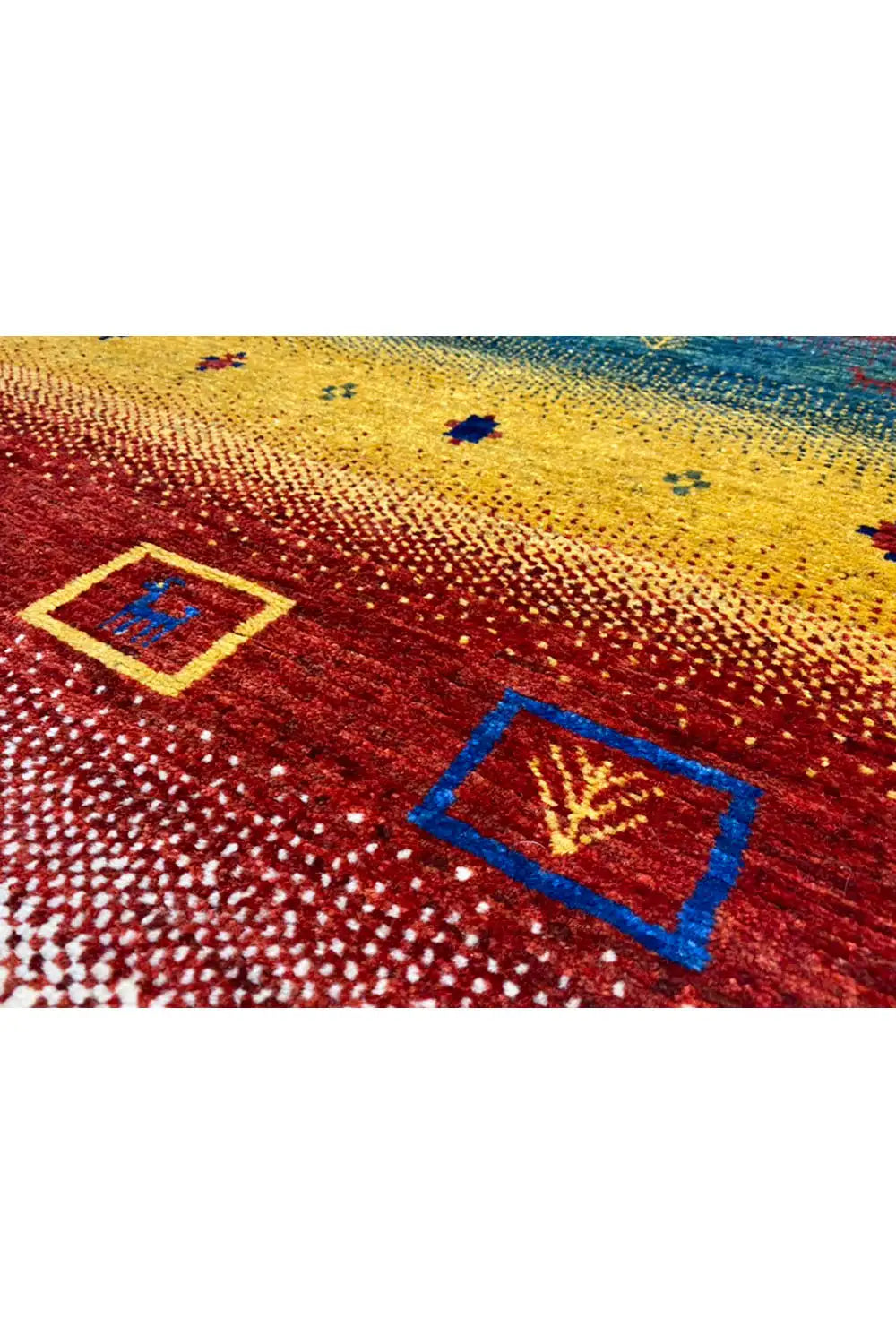 Close-up of a Gabbeh rug: square red and blue ornaments on a yellow surface