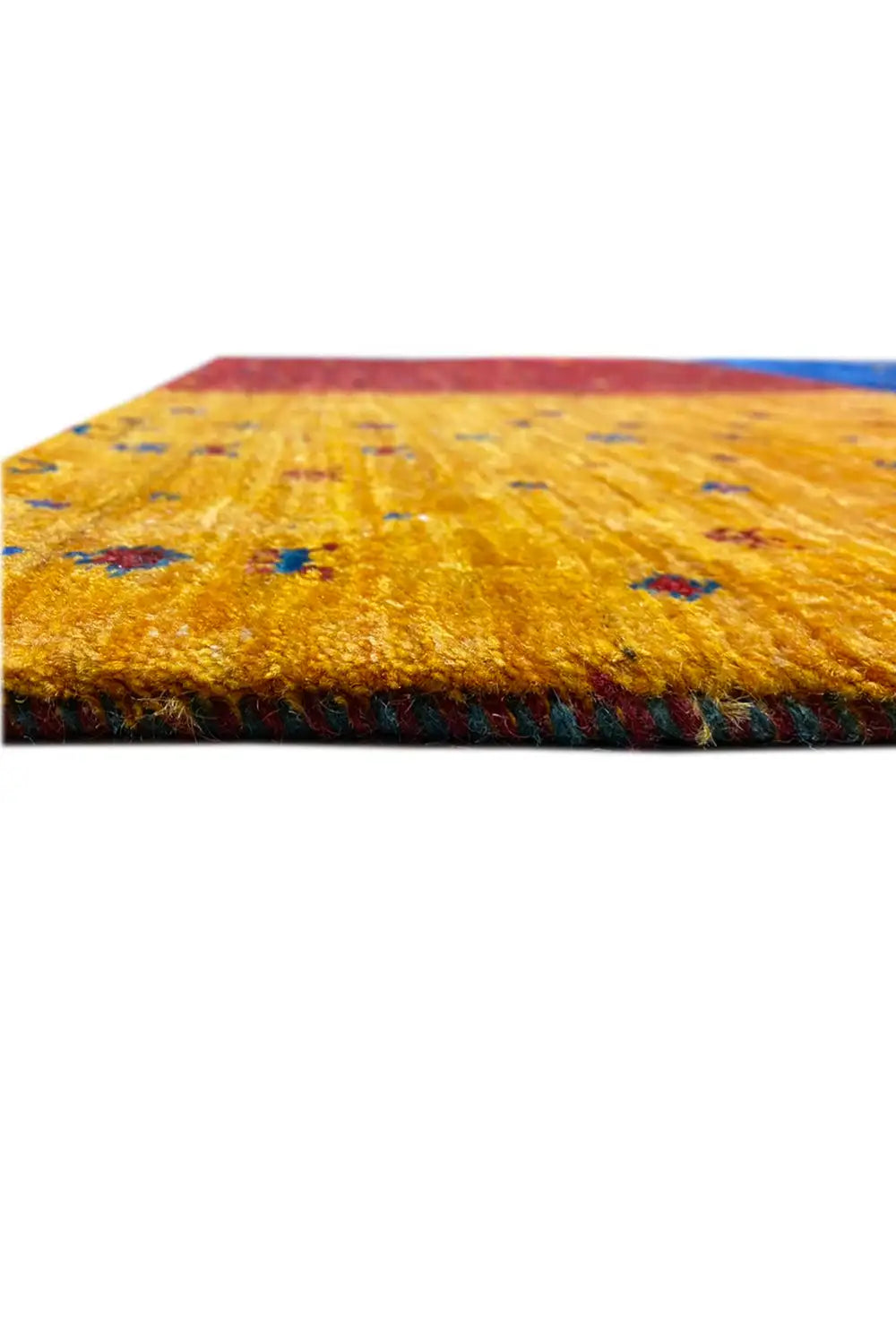 Close-up of a Gabbeh rug: yellow pile with red and blue accents, appearing hand-knotted