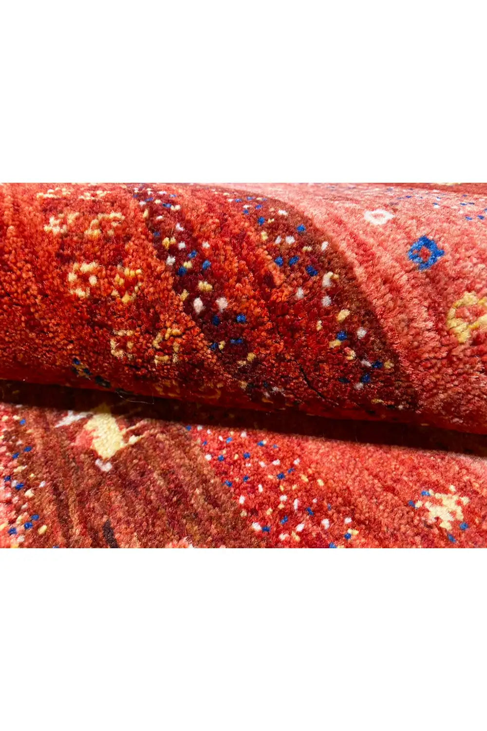 Gabbeh rug detail, reddish-brown pile with colorful motif areas and border edge