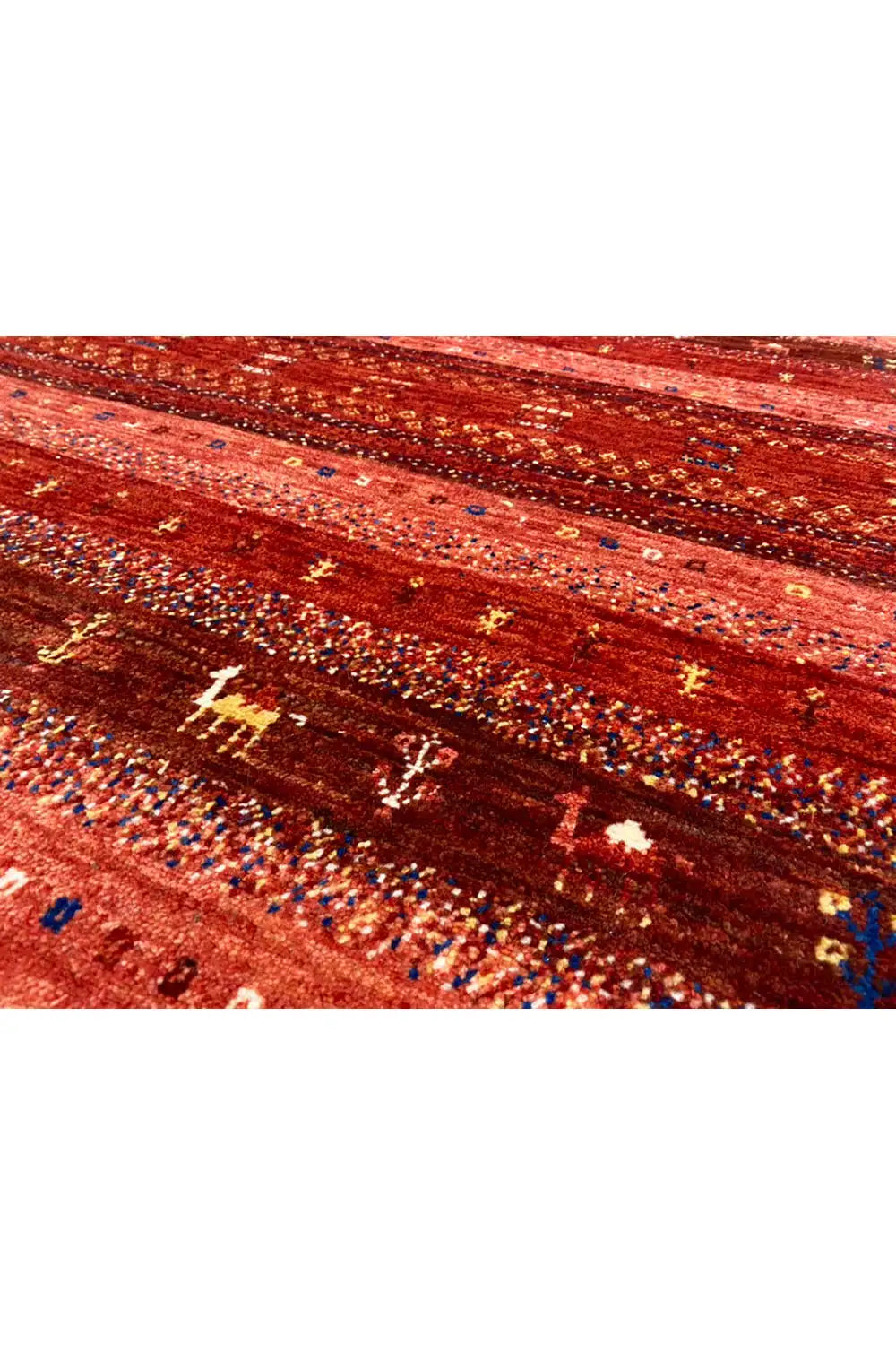 Close-up of a Gabbeh rug, red-brown stripes with golden and blue symbols