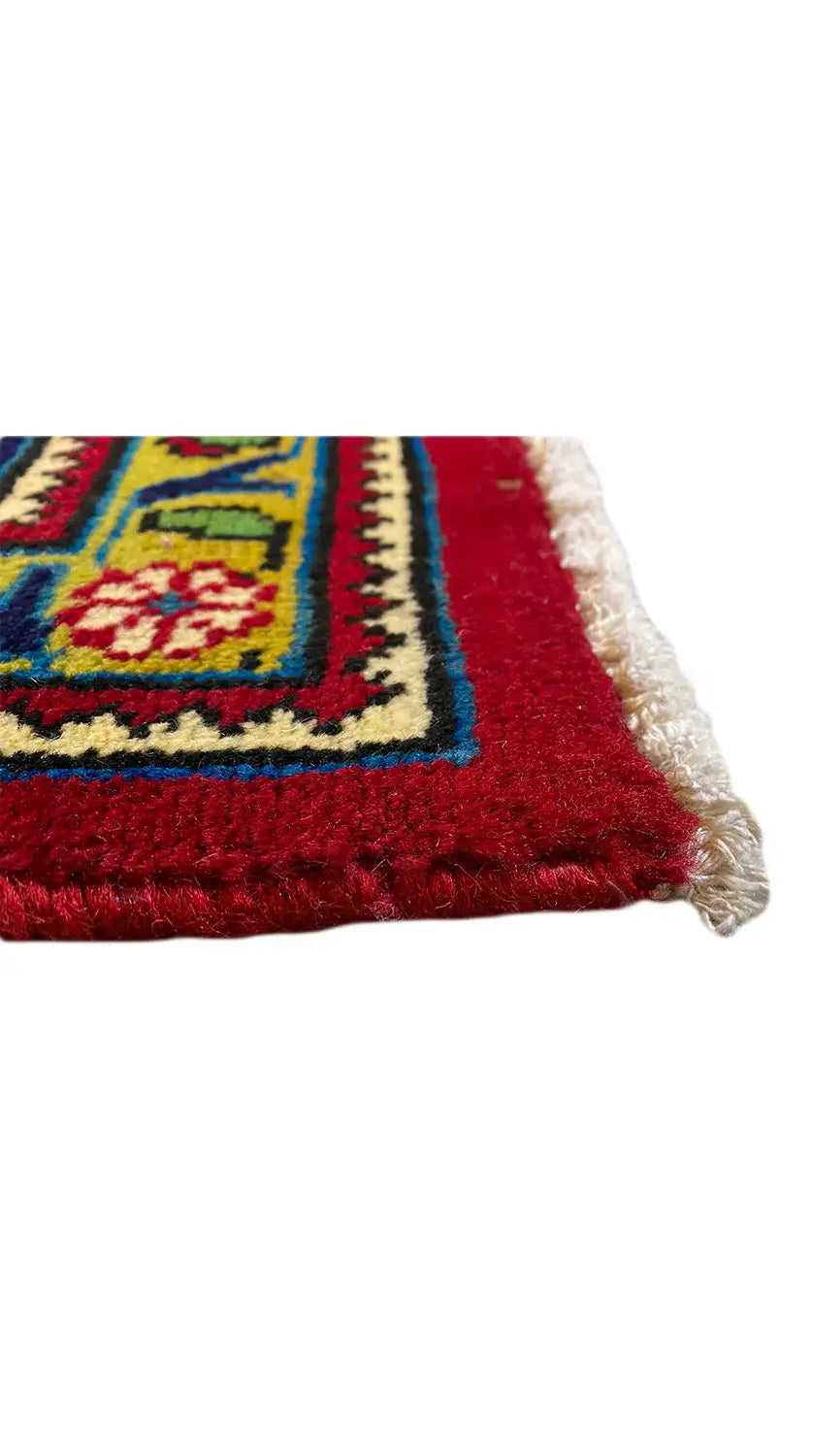 Rug edge with fringes, red field with a blue border and yellow-green ornaments