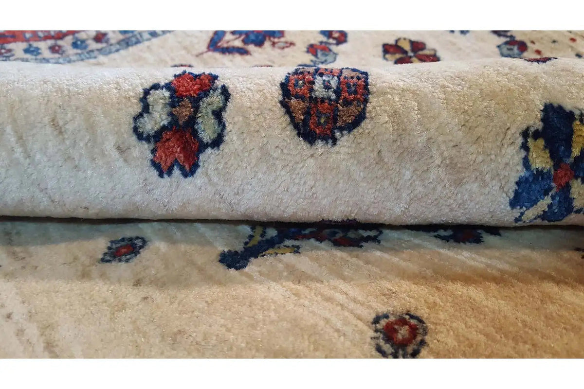 Carpet pile in detail with a beige base and blue and red pattern accents