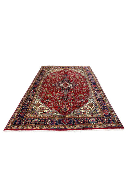 Rectangular Oriental rug with a red background, blue border, and ornamental medallions