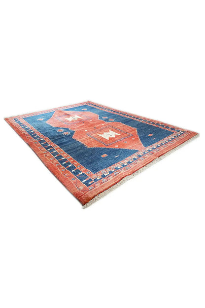 Rug diagonally: blue field with an orange-red central motif and an all-around patterned border